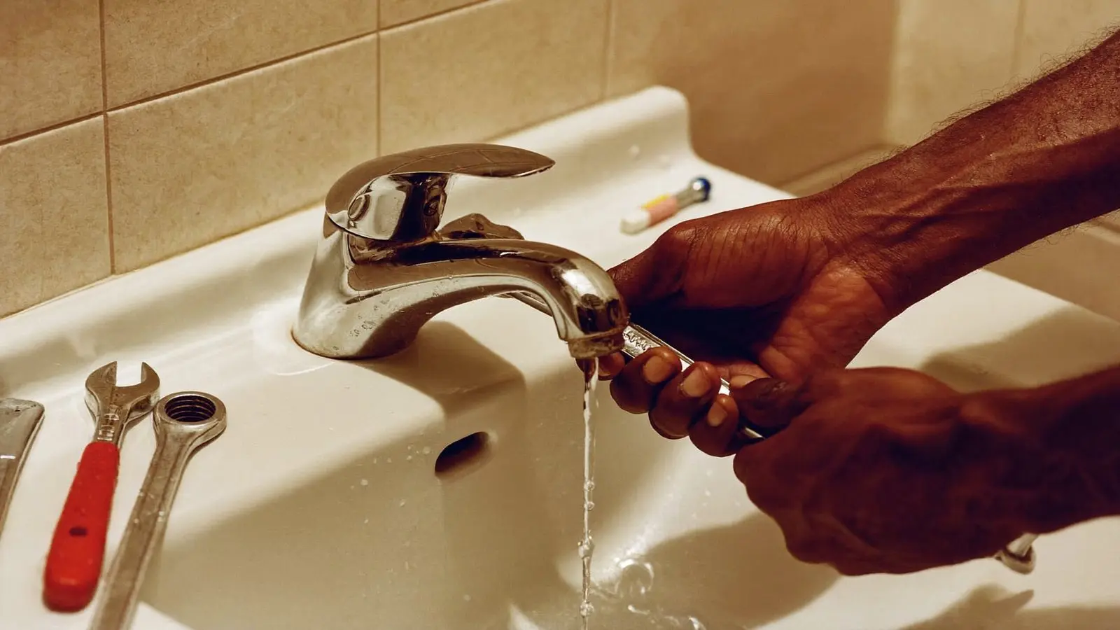 Gros plan d'un plombier réparant un robinet de salle de bain à Dakar